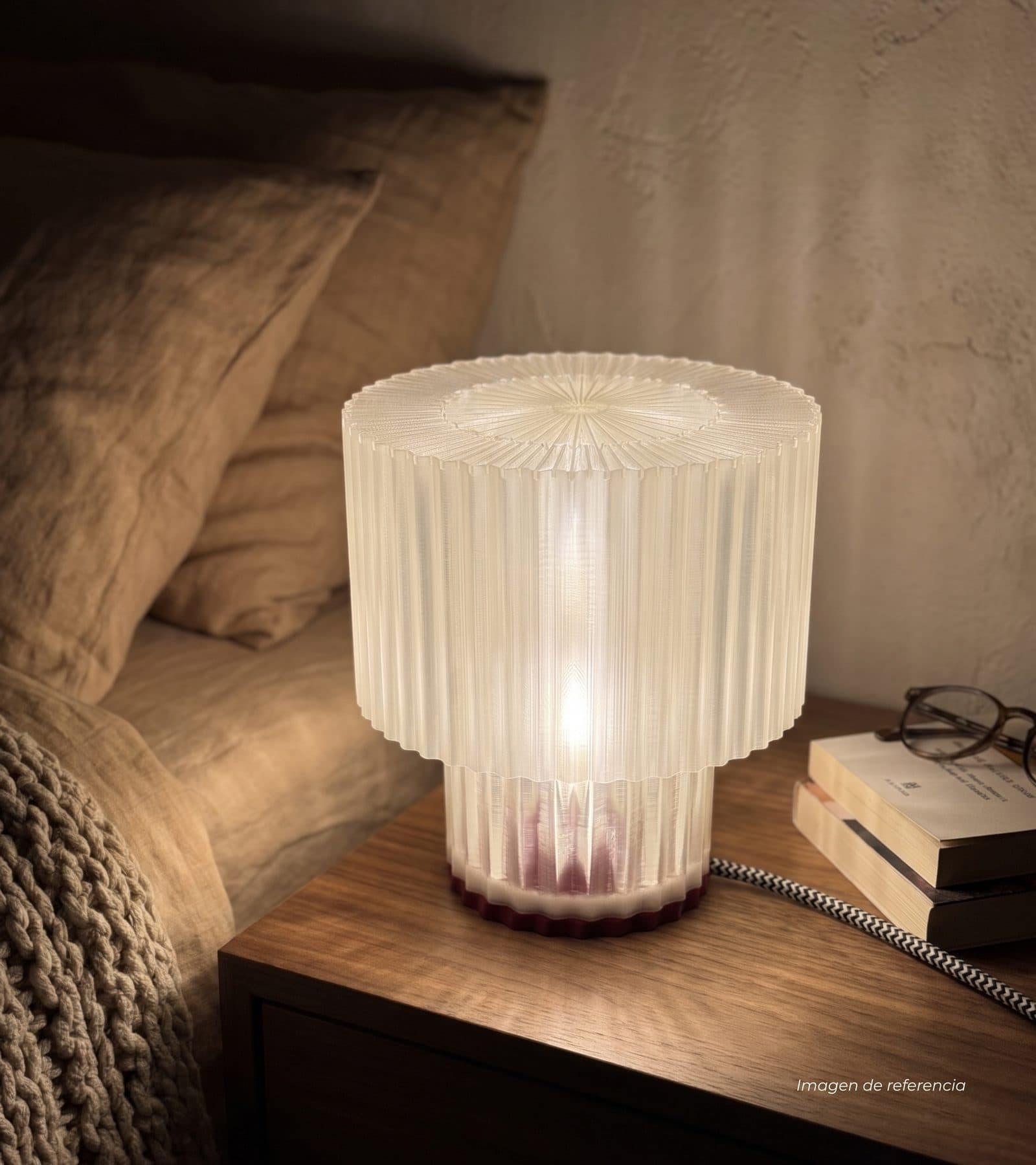 Lámpara Greta encendida en una mesa de noche junto a la cama