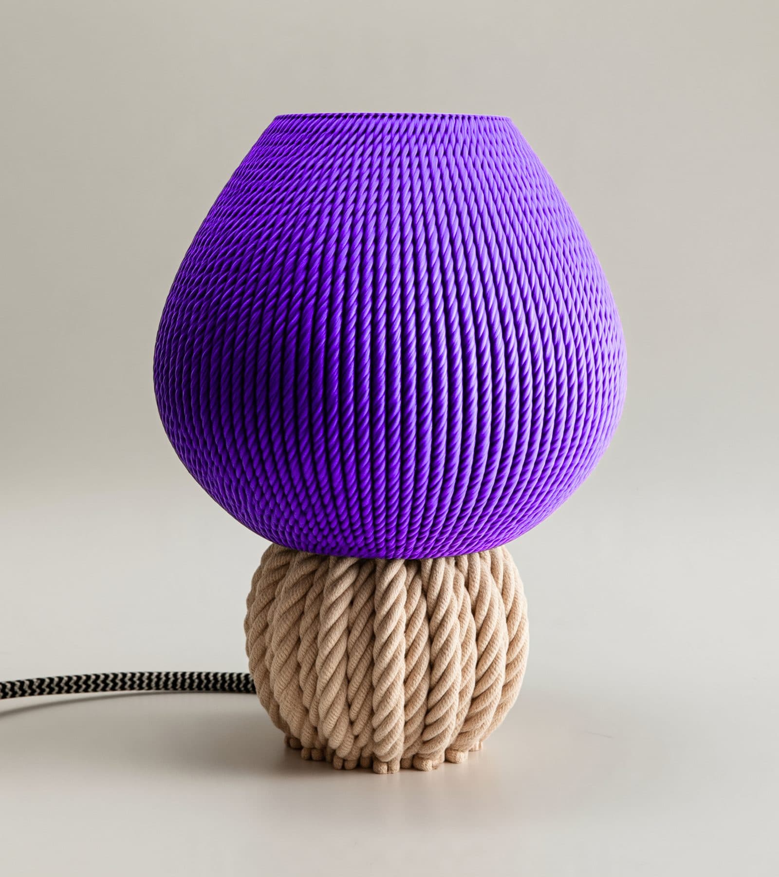 Lámpara Medusa lavanda apagada, sobre su base crema de nudos de cuerda